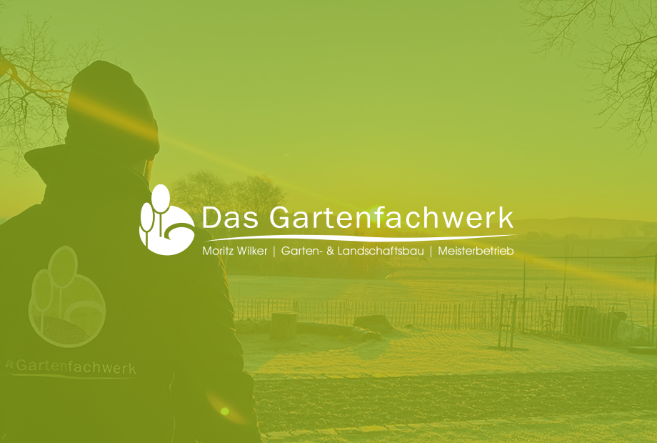 Eine Person in Arbeitskleidung betrachtet einen weitläufigen Garten, umgeben von einem Zaun.
